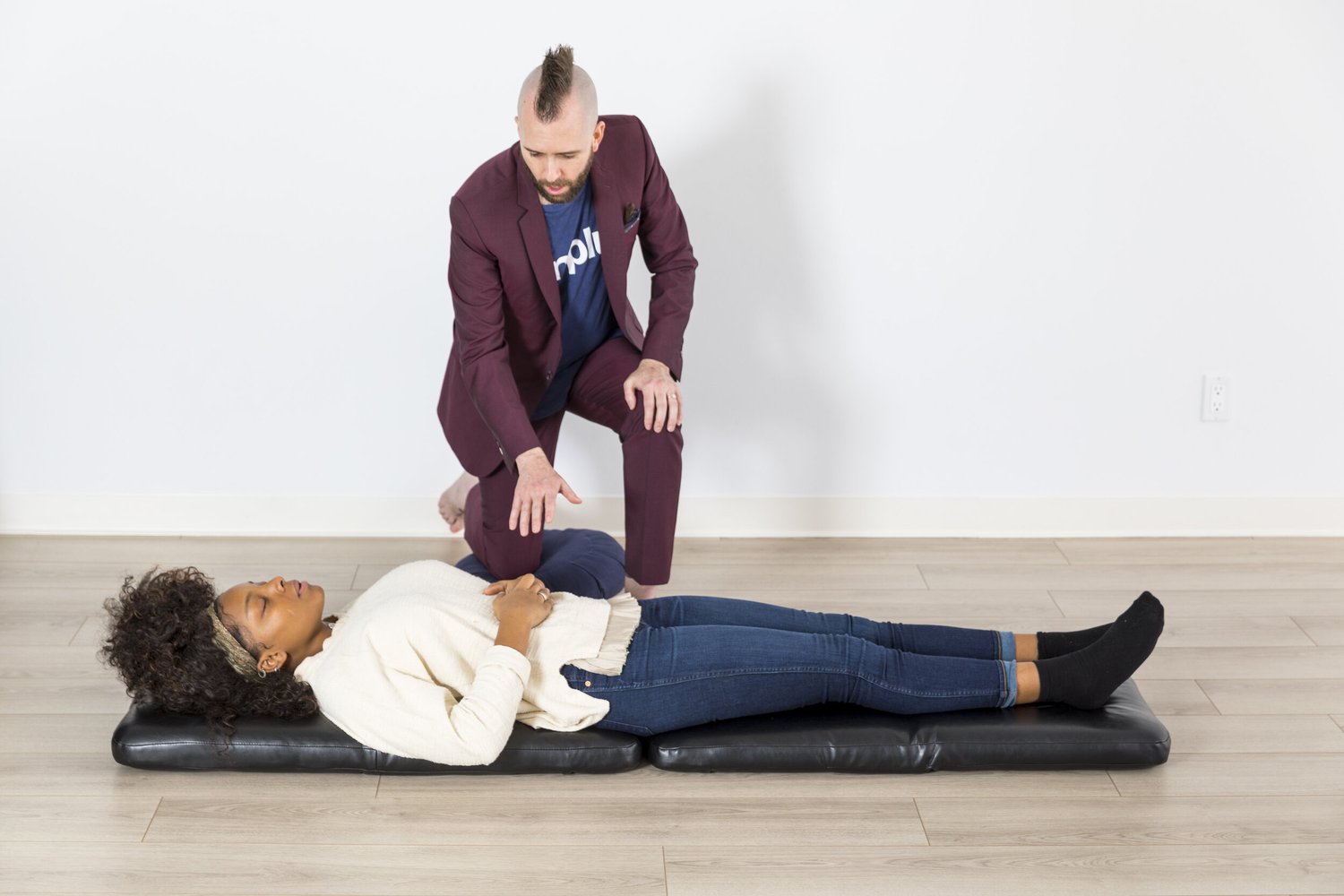A one-to-one Breathwork for Recovery session, facilitator guiding a client lying on a mat