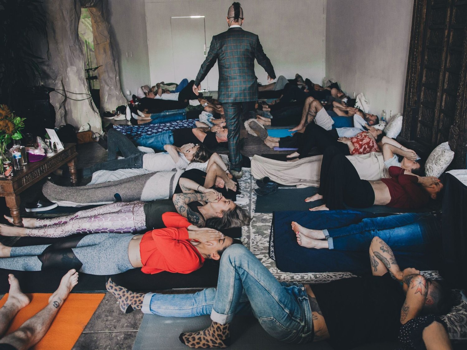 A large group breathwork session in progress, participants lying on mats
